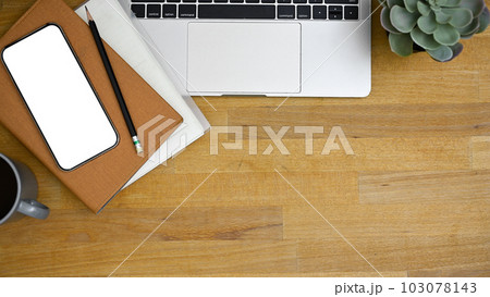 Workspace top view with laptop, smartphone mockup, and copy space on wooden tabletop. Workspace top view with laptop, smartphone mockup, and copy space on wooden tabletop. 103078143