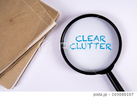 Clear Clutter. Magnifying glass and book on white background 103080107