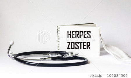 Herpes medicine concept. Notepad with the word herpes zoster and stethoscope with medical mask. 103084303