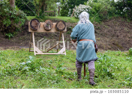 Medieval man practicing axe throwing 103085110