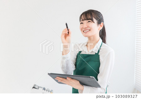 コンビニ・スーパーでタブレット端末を使って在庫管理をする店員・バイトの女性 コンビニ・スーパーでタブレット端末を使って在庫管理をする店員・バイトの女性 103089327