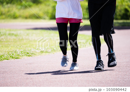 公園でランニングをする若いカップルの足元 103090442