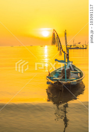 Moored boats during sunrise with yellow sky in Kenjeran, Surabaya, Indonesia. 103091117