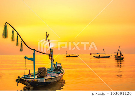 Moored boats during sunrise with yellow sky in Kenjeran, Surabaya, Indonesia. Moored boats during sunrise with yellow sky in Kenjeran, Surabaya, Indonesia. 103091120
