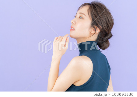 パープルバックでスキンケアをする若い女性 103091330