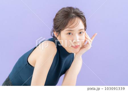 パープルバックでスキンケアをする若い女性 103091339