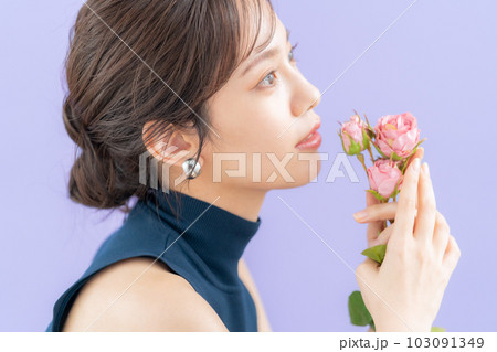 パープルバックで薔薇持つ若い女性 103091349