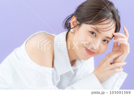 パープルバックでスキンケアをする若い女性 103091369