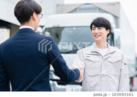 握手するビジネスマンと大型トラックの運転手 103093161
