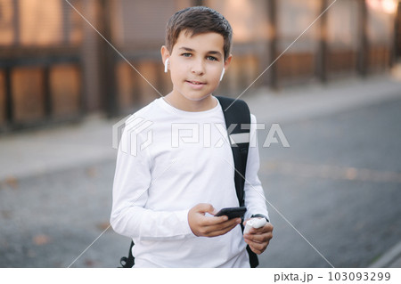 Teenage boy use wireless headphones for listening music 103093299