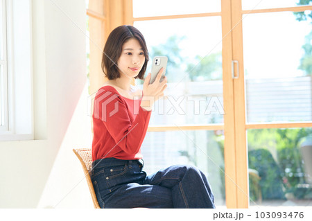 私服の若い女性　リビング　スマホ 103093476