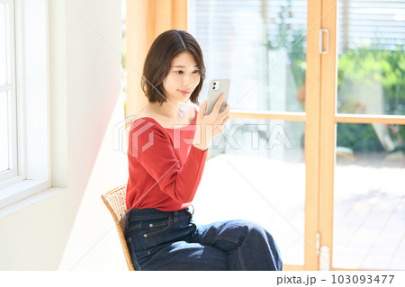 私服の若い女性　リビング　スマホ 103093477