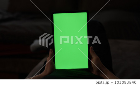 Man at home lying on a couch with tablet pc with green screen Man at home lying on a couch with tablet pc with green screen 103093840