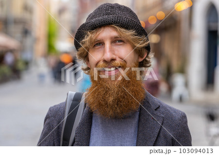 Happy young man smiling looking away dreaming, resting, good news, feel satisfied in city street 103094013