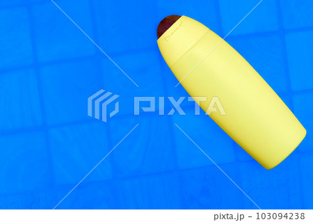 Yellow plastic bottle for detergents and shampoos on a checker blue background Yellow plastic bottle for detergents and shampoos on a checker blue background 103094238