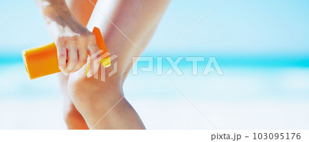 Closeup on woman applying sun screen creme on beach 103095176