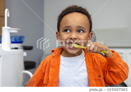 African-american boy looking involved while brushing his teeth 103097065