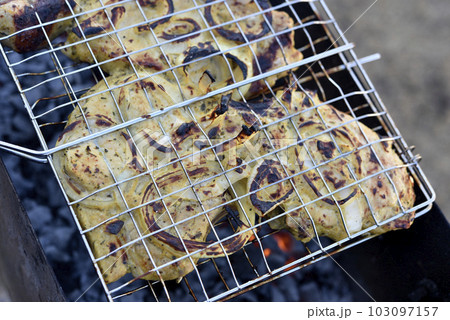 Pork meat in an iron mesh. Barbecue meat. Roast pork. Pork loin. 103097157