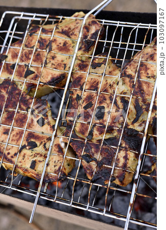Pork meat in an iron mesh. Barbecue meat. Roast pork. Pork loin. 103097167