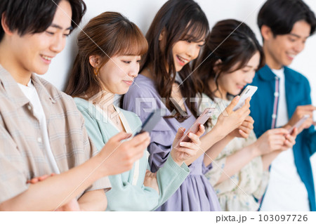 スマホを見る若い男女 103097726