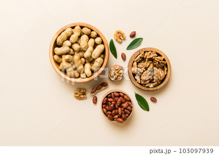 Walnut kernel halves, in a wooden bowl. Close-up, from above on colored background. Healthy eating Walnut concept. Super foods with copy space Walnut kernel halves, in a wooden bowl. Close-up, from above on colored background. Healthy eating Walnut concept. Super foods with copy space 103097939