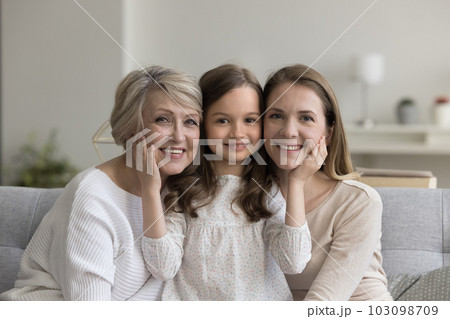 Little girl posing for camera with granny and mother Little girl posing for camera with granny and mother 103098709