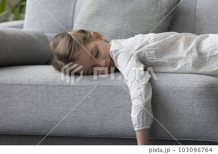 Child closed eyes lying on couch at home rest alone 103098764