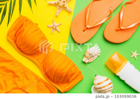 Woman swimwear and beach accessories flat lay top view on colored background Summer travel concept. bikini swimsuit, straw hat and seasheels. Copy space Top view Woman swimwear and beach accessories flat lay top view on colored background Summer travel concept. bikini swimsuit, straw hat and seasheels. Copy space Top view 103099036