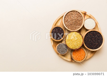 Various superfoods in smal bowl on colored background. Superfood as rice, chia, quinoa, lentils, nuts, sesame seeds, almonds. top view 103099071