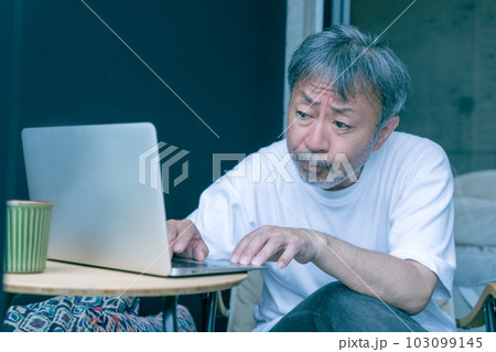 パソコン作業をする困った顔のミドルエイジの男性 パソコン作業をする困った顔のミドルエイジの男性 103099145