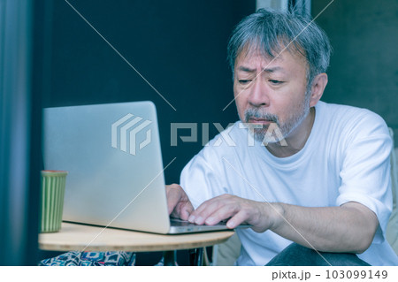 パソコン作業をする老眼のミドルエイジの男性 パソコン作業をする老眼のミドルエイジの男性 103099149