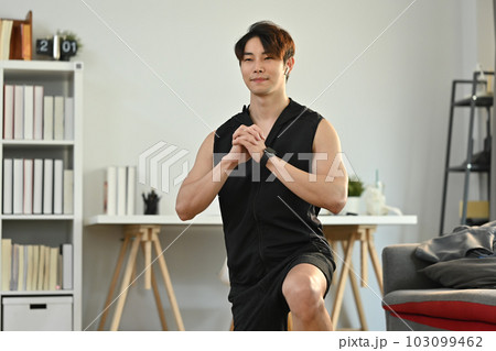 Handsome male athlete in fitness clothes working out in the morning at home. Healthy lifestyle concept 103099462