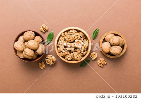 Walnut kernel halves, in a wooden bowl. Close-up, from above on colored background. Healthy eating Walnut concept. Super foods with copy space Walnut kernel halves, in a wooden bowl. Close-up, from above on colored background. Healthy eating Walnut concept. Super foods with copy space 103100282