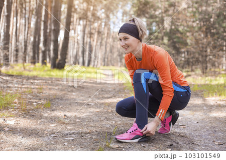 Women Runner tying shoelaces on sneakers. Women Runner tying shoelaces on sneakers. 103101549