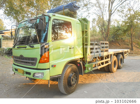 Green colored flatbed heavy trucks used to transport and distribute cements sacks from factory to points of sales or distributors networks shops around Asia Green colored flatbed heavy trucks used to transport and distribute cements sacks from factory to points of sales or distributors networks shops around Asia 103102666