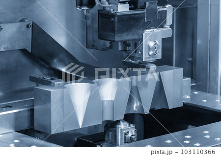 Closeup scene the wire EDM machine cutting the mold insert parts. Closeup scene the wire EDM machine cutting the mold insert parts. 103110366
