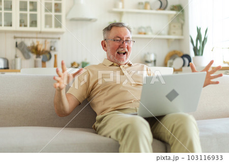 Excited middle aged senior man euphoric winner. Older mature grandfather looking at laptop reading great news getting good result winning online bid feeling amazed. Winning gesture 103116933