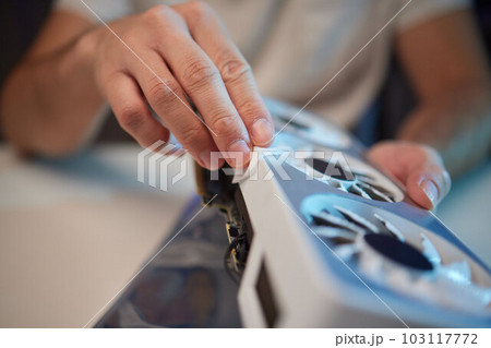 Changing the thermal paste on the graphics processor. Disassembled graphics card on the table. Old graphics card service. 103117772