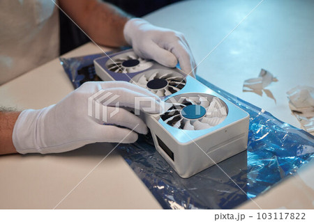 Changing the thermal paste on the graphics processor. Disassembled graphics card on the table. Old graphics card service. Changing the thermal paste on the graphics processor. Disassembled graphics card on the table. Old graphics card service. 103117822