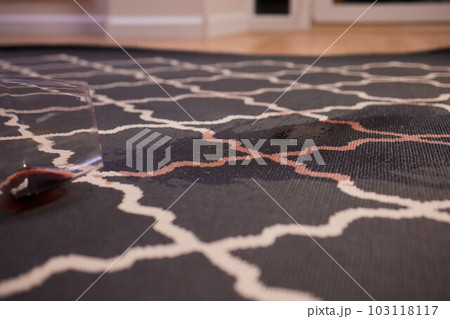 glass of red wine fell on carpet, drink spilled on floor. 103118117