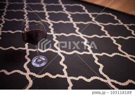 glass of red wine fell on carpet, drink spilled on floor. 103118189