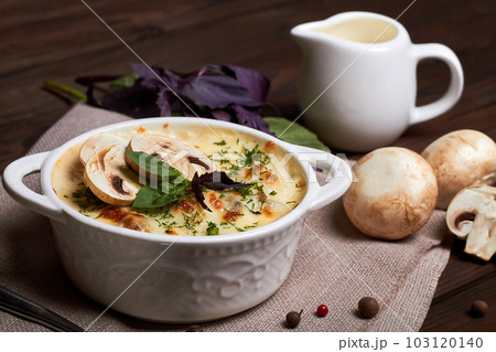 Chicken julienne with cheese, mushrooms and herbs in white plate on wooden board Chicken julienne with cheese, mushrooms and herbs in white plate on wooden board 103120140