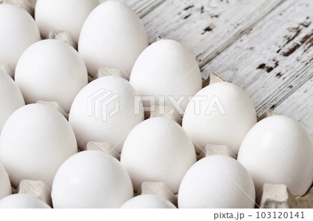 Close-up of Cardboard tray with white chicken eggs on wooden background 103120141