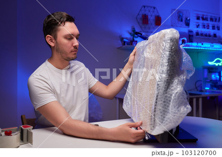 young man packing a monitor in a cardboard box. young man packing a monitor in a cardboard box. 103120700