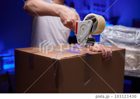 young man packing a monitor in a cardboard box. young man packing a monitor in a cardboard box. 103121430