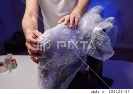 young man packing a monitor in a cardboard box. young man packing a monitor in a cardboard box. 103121457