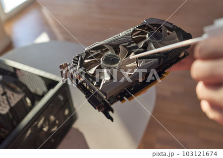 Employee cleans an open old computer with air duster cleaning spray gun in the workshop closeup. Employee cleans an open old computer with air duster cleaning spray gun in the workshop closeup. 103121674