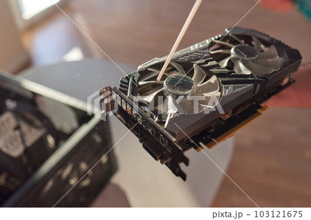 Employee cleans an open old computer with air duster cleaning spray gun in the workshop closeup. 103121675