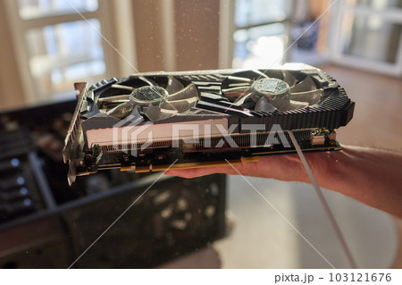Employee cleans an open old computer with air duster cleaning spray gun in the workshop closeup. 103121676