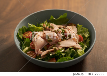 Salad with roasted turkey and cherry tomatoes decorated with pumpkin seeds in blue bowl Salad with roasted turkey and cherry tomatoes decorated with pumpkin seeds in blue bowl 103122225